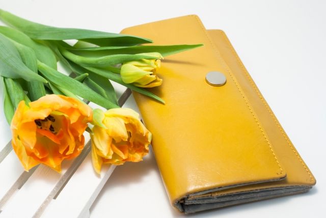 お花と一緒に置かれた黄色の長財布
